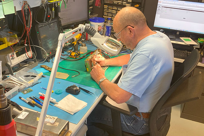 Robert Peterson, electronic technician II, tests a circuit board.  Robert Peterson, electronic technician II, tests a circuit board.