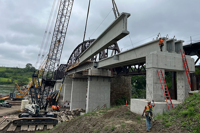 Crews erect the precast girders for span 11.  Crews erect the precast girders for span 11.