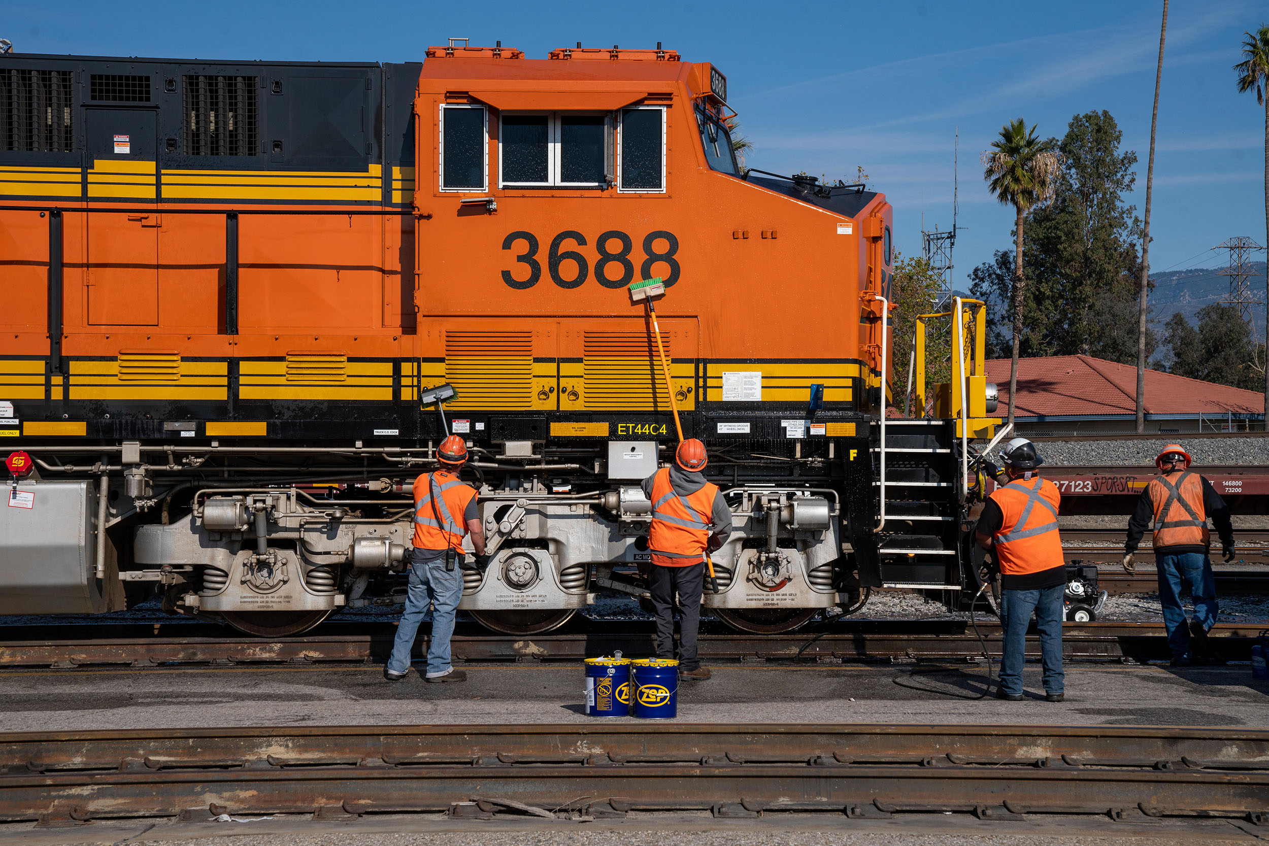 Yard crew washing a locomotive parked at the San Bernardino Intermodal Facility in San Bernardino, California. Yard crew washing a locomotive parked at the San Bernardino Intermodal Facility in San Bernardino, California.