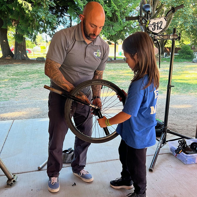 Azus shares bike maintenance with a rider.  Azus shares bike maintenance with a rider.