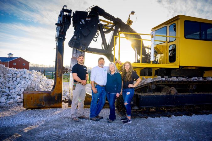 Pictured from left: Elizabeth’s brother, Adam; father, Wayne; mother, Lori; and Elizabeth standing with their plow used for installing soil drainage  Pictured from left: Elizabeth’s brother, Adam; father, Wayne; mother, Lori; and Elizabeth standing with their plow used for installing soil drainage