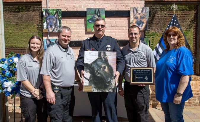 Schaffer at the WRTP K-9 memorial holding a photo of Faust.  Schaffer at the WRTP K-9 memorial holding a photo of Faust.