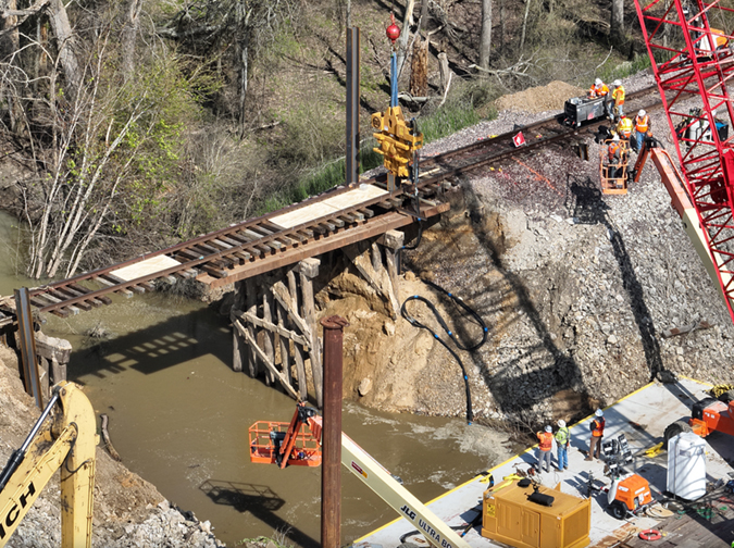 Crews work to replace the washed-out culvert with a bridge. Crews work to replace the washed-out culvert with a bridge.