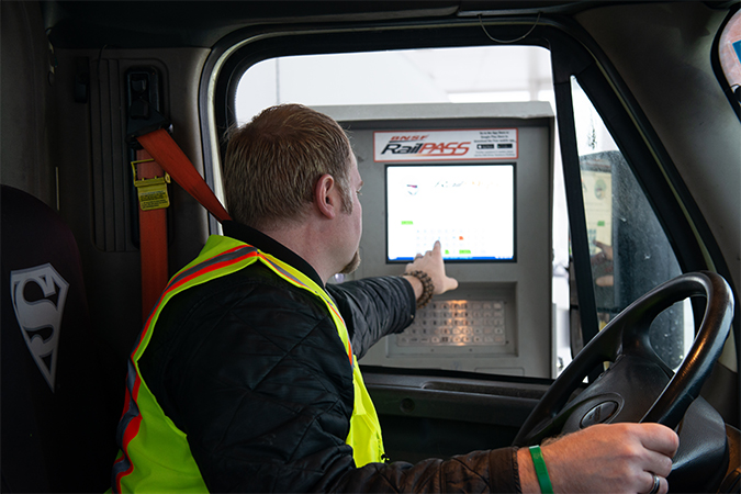 A truck driver uses a kiosk at the entrance to a BNSF intermodal facility.  A truck driver uses a kiosk at the entrance to a BNSF intermodal facility.