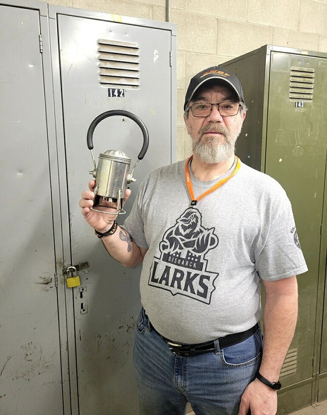 Jeff Kessel standing in front of his locker at work, holding his father’s 30-year-old carman lantern  Jeff Kessel standing in front of his locker at work, holding his father’s 30-year-old carman lantern