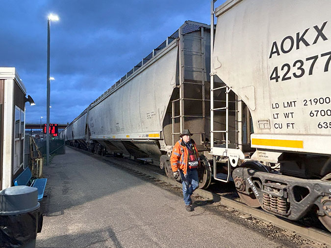 Switchman Lee Flandrich inspects covered hopper cars during the humping process at Northtown.  Switchman Lee Flandrich inspects covered hopper cars during the humping process at Northtown.