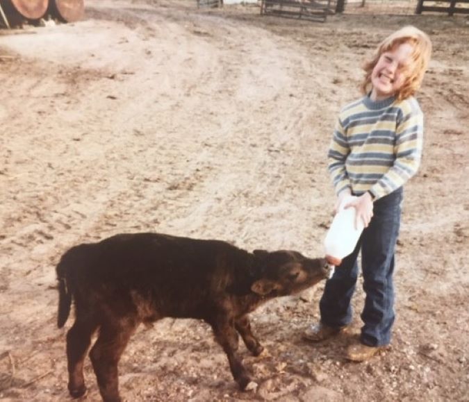 Lambley bottle-feeding a calf in her childhood  Lambley bottle-feeding a calf in her childhood