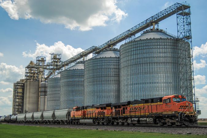 A BNSF grain train passes a grain facility  A BNSF grain train passes a grain facility