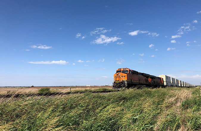 An intermodal train passing through billowing grass in Enid, Oklahoma An intermodal train passing through billowing grass in Enid, Oklahoma
