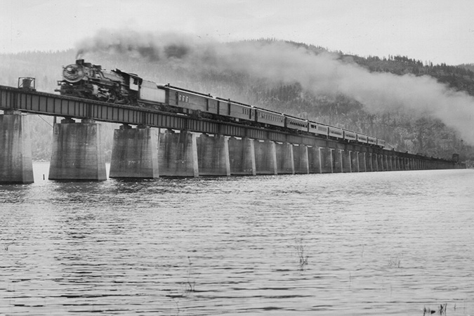 A Northern Pacific locomotive crosses the bridge heading north, with Gold Hill in the background. Courtesy of Bonner County Historical Society. A Northern Pacific locomotive crosses the bridge heading north, with Gold Hill in the background. Courtesy of Bonner County Historical Society.