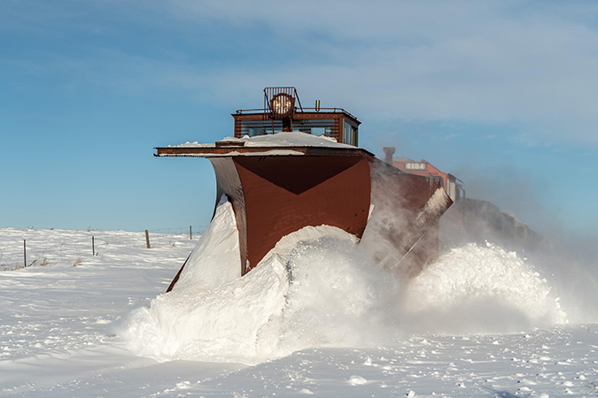 A Russell, or Flier, snowplow clearing out a path on a sunny day. A Russell, or Flier, snowplow clearing out a path on a sunny day.