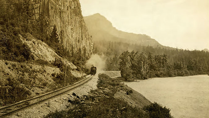 An SP&S train steams along the Columbia River near Beacon Rock in 1909. An SP&S train steams along the Columbia River near Beacon Rock in 1909.