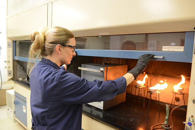 Senior Engineer I Rachel Flott analyzes diesel fuel to determine the ash content. The fuel is ignited to allow it to burn until only ash and carbon remain.   Senior Engineer I Rachel Flott analyzes diesel fuel to determine the ash content. The fuel is ignited to allow it to burn until only ash and carbon remain.